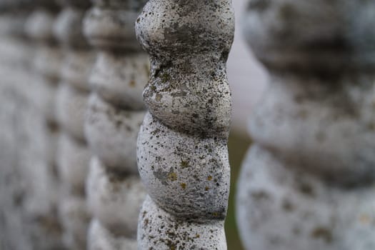 Background texture of an old gray concrete fence with patterned posts.