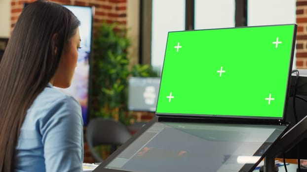 Asian woman using game developing software and greenscreen display on monitors. Artistic editor working with blank chroma key template on isolated copyspace, planning 3d project.