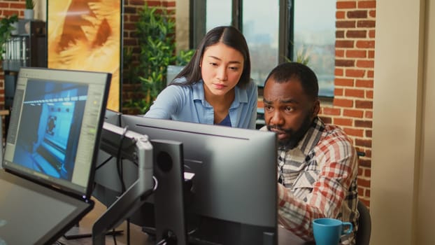 Modern technology studio employees using computers to develop new graphics interface in office, doing teamwork to create professional content. Working with 3d software to render on pc.