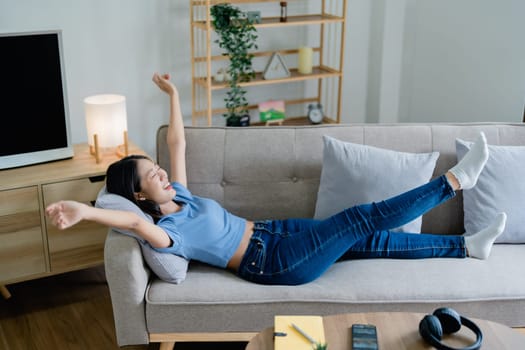 Home lifestyle woman relaxing sleeping on sofa patio living room. Happy lady lying down on comfortable pillows taking a nap for wellness and health. Tropical vacation