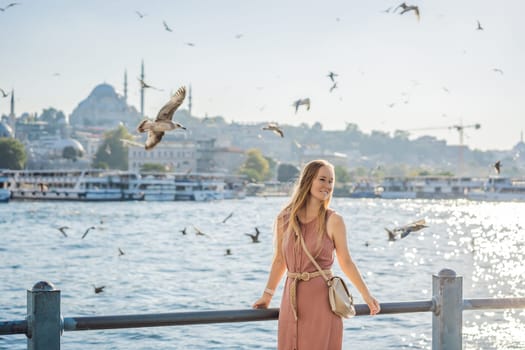 Young woman traveler in pinc dress enjoying great view of the Bosphorus and lots of seagulls in Istanbul.