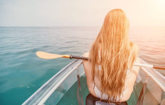 Woman in kayak back view. Happy young woman with long hair floating in transparent kayak on the crystal clear sea. Summer holiday vacation and cheerful female people having fun on the boat.