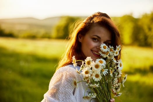 close portrait of a laughing woman looking at the camera in nature with a bouquet of daisies. High quality photo