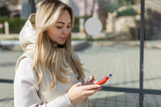 Cheerful female tourist using mobile phone for view map via network and continue her walk in strange city, beautiful hipster girl in good mood consult bus schedule via internet on her cell telephone .