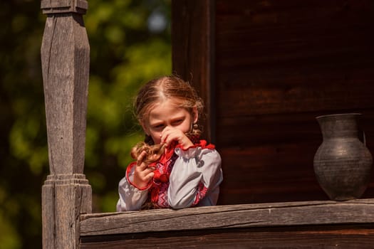 Girl in Ukrainian national dress with a jug outdoors