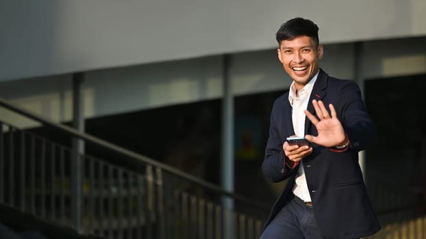 Shot of businessman using smartphone while walking in business district. Modern lifestyle, technology and business concept.