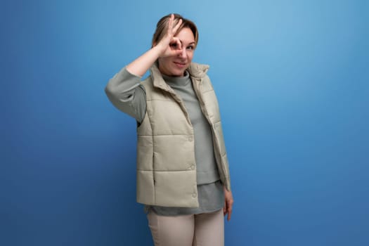 portrait of funny blond young woman with grimace on studio background.