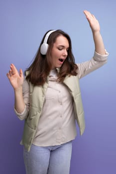 energetic young brunette woman relaxing to music using headphones and mobile phone.