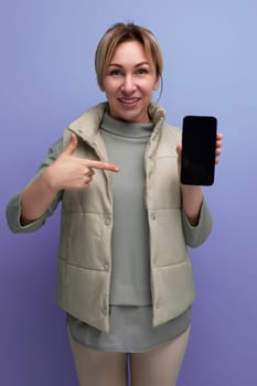 pretty 30s young woman with white hair in casual style shows smartphone screen with mockup for advertising.