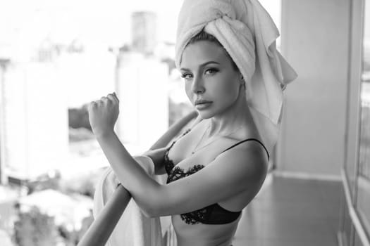 Young woman with beautiful body is wearing sexy lingerie and posing on the balcony.