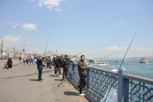 ISTANBUL, Türkiye - May 02, 2023: fishermen and tourists on the Galata bridge.