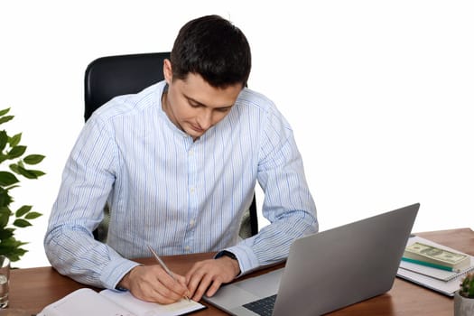 businessman in blue shirt taking notes, using laptop computer on white background
