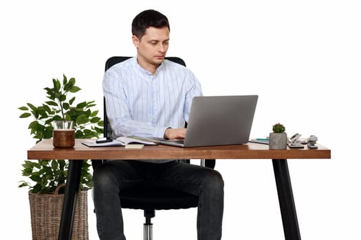 young man using laptop computer for online work at table on white background