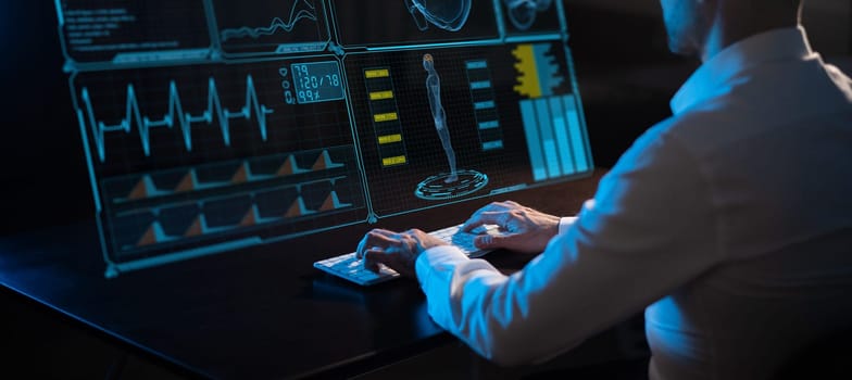 Caucasian man sits in the dark in front of a virtual menu. Close-up of male hands on the keyboard