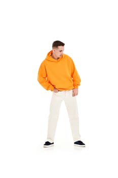 young handsome man in orange blank sweatshirt with space for your logo or design on white background. Mockup for print Full length