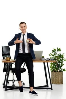 Successful caucasian businessman holding toy house in the office. real estate insurance