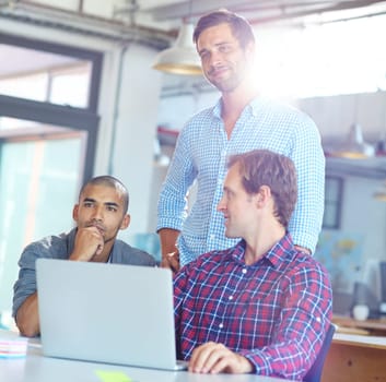 Intelligence without ambition is like a bird without wings. a diverse group of designers working on a laptop in an office