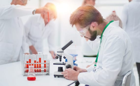 close up. young scientist sitting at a table in the laboratory. concept of health protection.