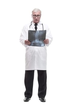 full-length. qualified mature doctor looking at the x-ray. isolated on a white background.