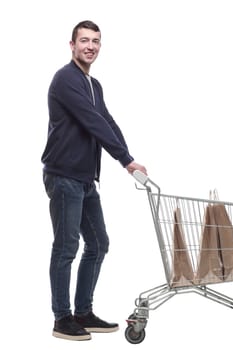 smiling young man with a shopping cart . isolated on a white background.