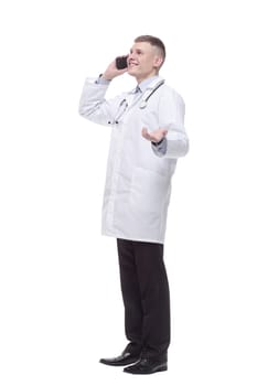 in full growth. young doctor with a smartphone. isolated on a white background.