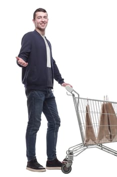 smiling young man with a shopping cart . isolated on a white background.