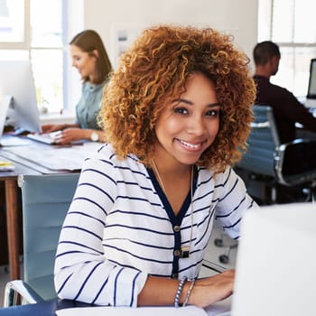 Portrait of black woman in creative agency with smile, confidence and success at design startup. Happy designer in modern office, manager or team leader working at laptop desk with digital technology.