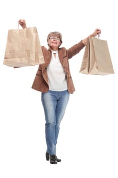 Mature woman holding bags smiling and looking at camera isolated over white background
