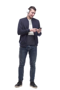 young man with a smartphone listening to music through headphones. isolated on a white