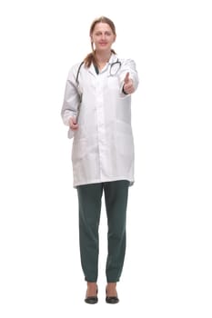 Attractive female doctor standing on white background holding clipboard and doing paperwork, looking up at camera.