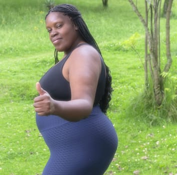 black , obese and positive woman doing sport in the park to lose weight. High quality photo
