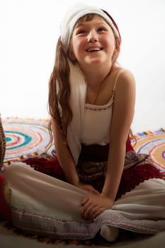 Portrait of Little girl in a stylized Tatar national costume on a white background in the studio. Photo shoot of funny young teenager who is not a professional model