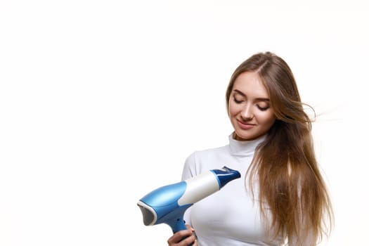 Portrait of attractive cheerful girl drying long hair isolated on white background
