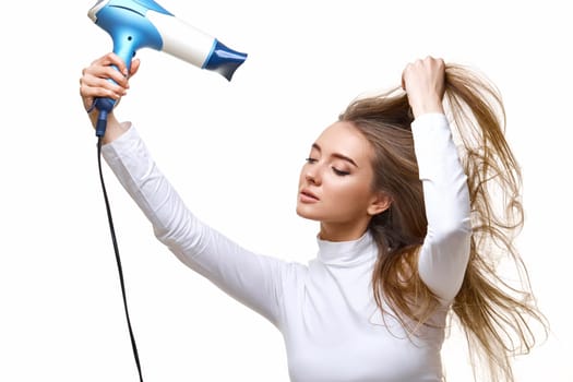 Portrait of attractive cheerful girl drying long hair isolated on white background