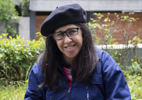 close-up of smiling painter wearing glasses and beret and overalls. High quality photo