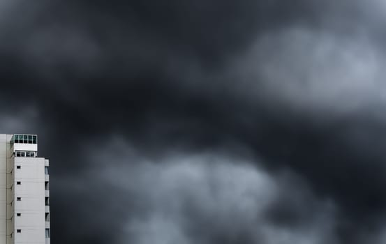 A long exposure photography of skyscrapers rising under the threatening, dark clouds of a storm, perfect for background and text space.