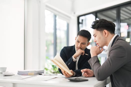 Asian business advisor meeting to analyze and discuss the situation on the financial report in the meeting room. Investment Consultant, Financial , teamwork ,brainstorming ,startup and accounting.