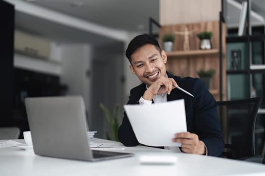 Businessman using laptop computer in office. Happy middle aged man, entrepreneur small business owner..