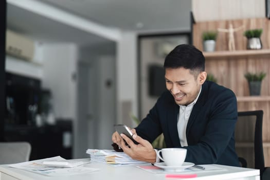 business asian man using smartphone at his office..