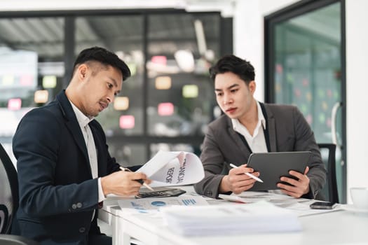 Asian business advisor meeting to analyze and discuss the situation on the financial report in the meeting room. Investment Consultant, Financial , teamwork ,brainstorming ,startup and accounting.