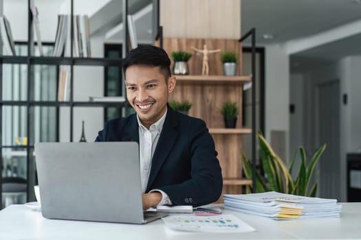 Businessman using laptop computer in office. Happy middle aged man, entrepreneur small business owner..