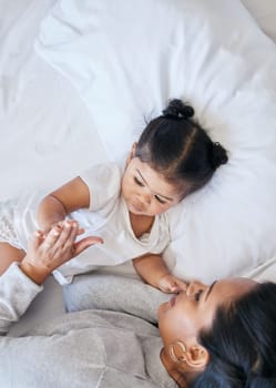 Baby, mother care and girl in a bedroom bed with parent support and love with happiness. Morning, house and bonding together of a mom and child holding hands feeling happy from motherhood in a home.