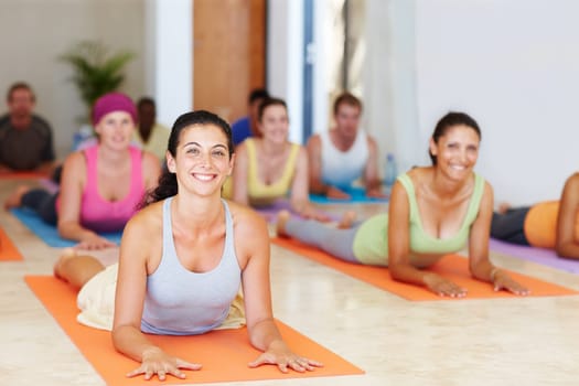 Portrait of a pretty mature woman lying on her stomach on her exercise mat - Yoga.