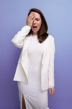 upset sad brunette young woman in a dress and jacket with a grimace.