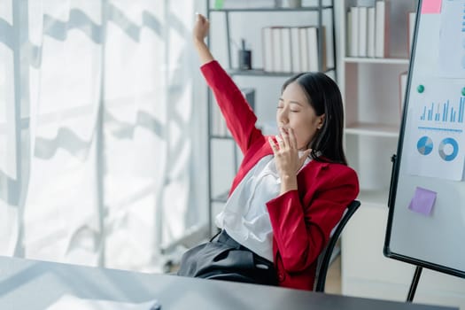 Rear view young businesswoman leaning back in comfortable chair, sitting in modern office, successful woman employee, planning future, visualizing, pondering project strategy