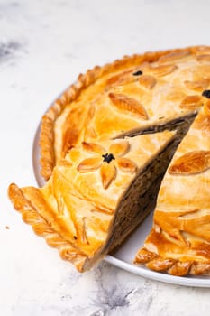 delicious homemade pie with minced meat and potatoes on a white plate.