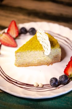 pistachio cheesecake with berries on a plate in a restaurant.