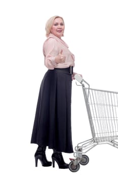 Happy blonde woman with shopping cart trolley in sale season. Shopaholic concept.