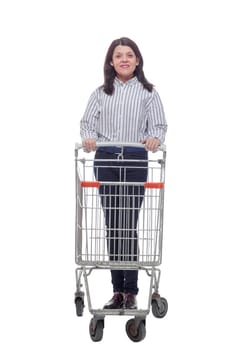 Full length portrait of a woman pushing a shopping trolley isolated on white background