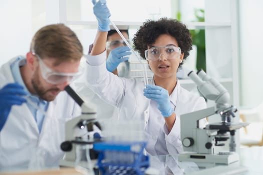 Team of Scientists Working Using Microscope, Analysing Microbiology Samples